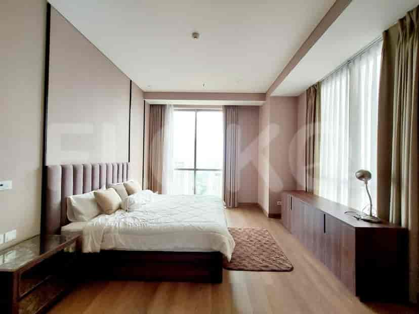Modern bedroom with a king-sized bed, large window, and wooden accents.
