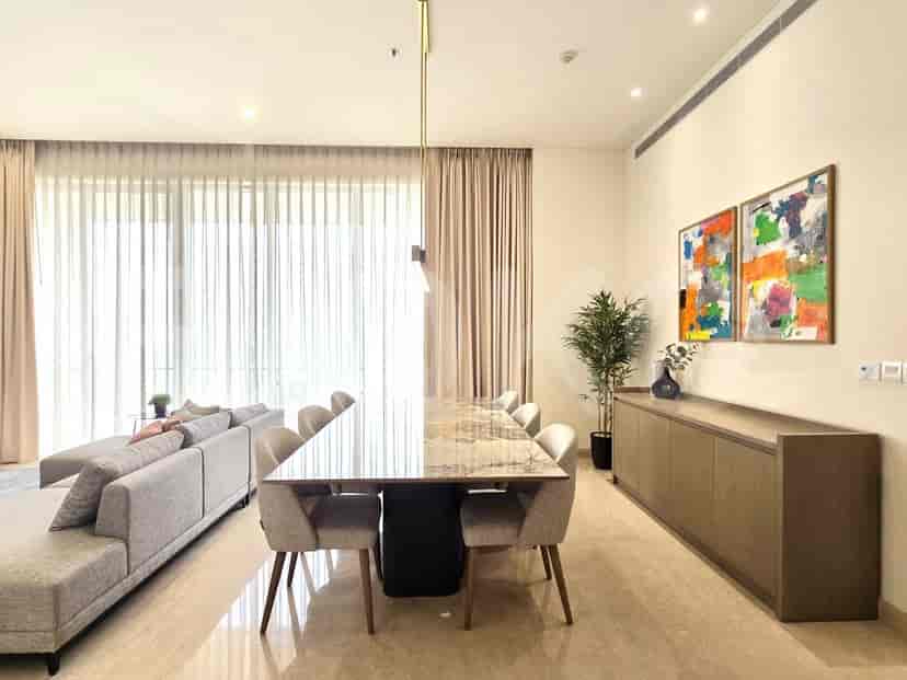 Area makan yang elegan dengan meja marmer dan karya seni.