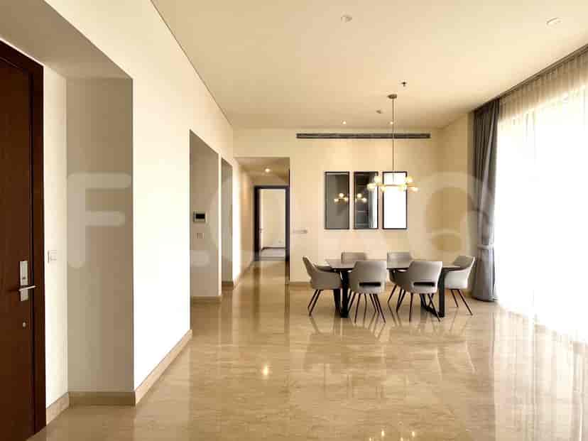 A spacious dining area connected to a hallway, with a dining table and chairs.