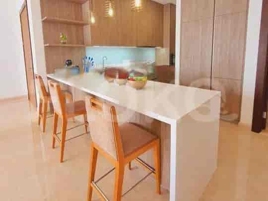 A modern kitchen with a white island, bar stools, and wooden cabinets.