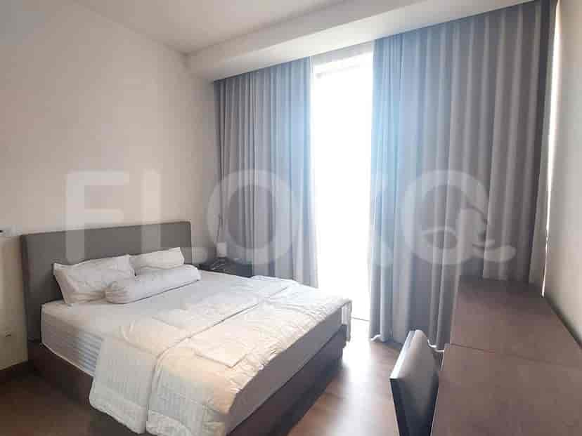 Bedroom with a king-size bed and a large window with curtains.