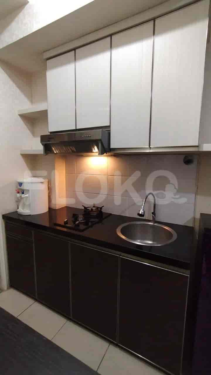 A kitchen with a sink, stove, and cabinets.