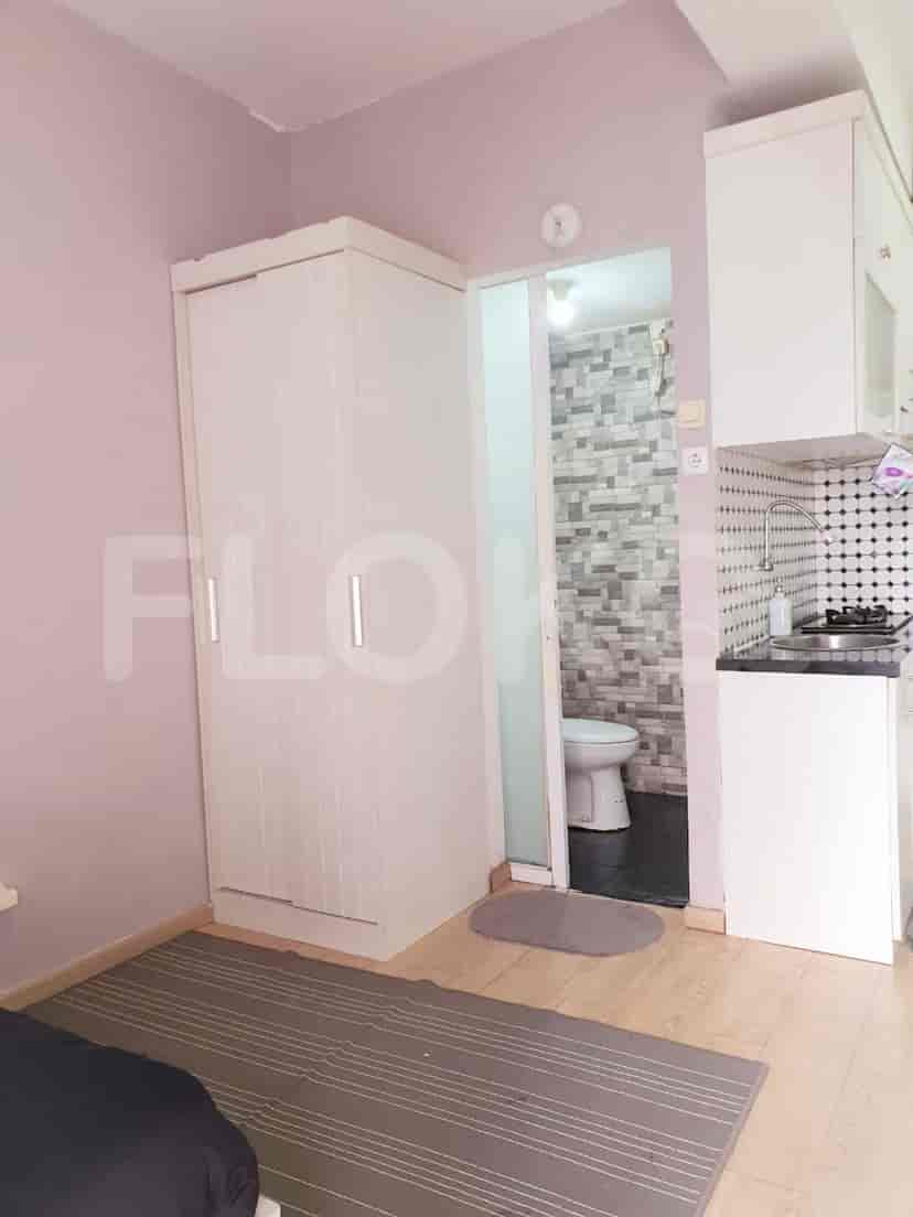 A compact studio layout featuring a wardrobe, and access to a small bathroom and kitchenette.