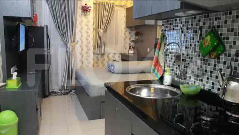 A small apartment showcasing a kitchen, sleeping area, and TV.