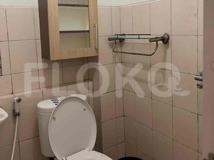 Small bathroom with a toilet and storage cabinet.