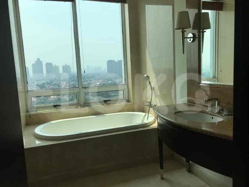 Kamar mandi dengan bak mandi, wastafel, dan jendela besar.