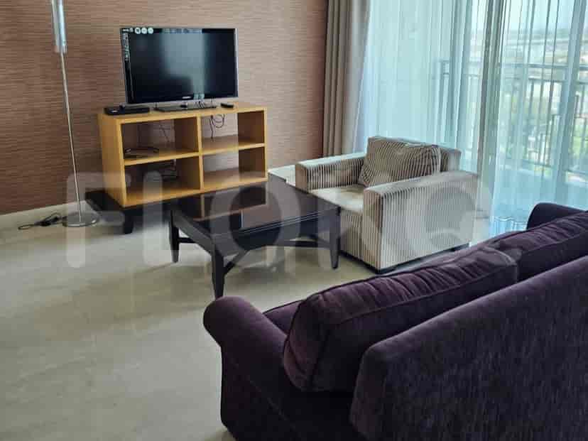 Living room with a television, sofa, and armchair.