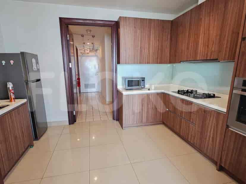 Dapur modern dengan lemari kayu, microwave, dan kompor gas.