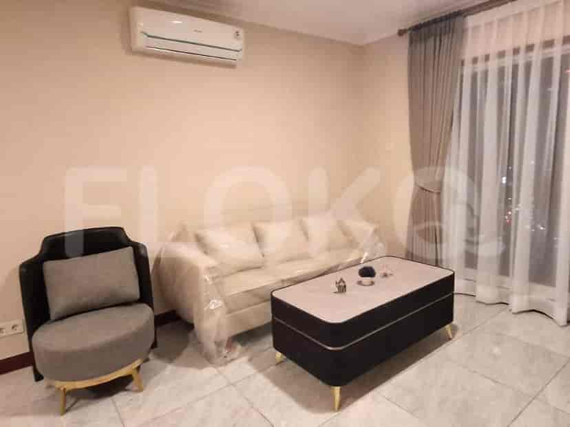 Living room with sofa and armchair, coffee table, and curtains.