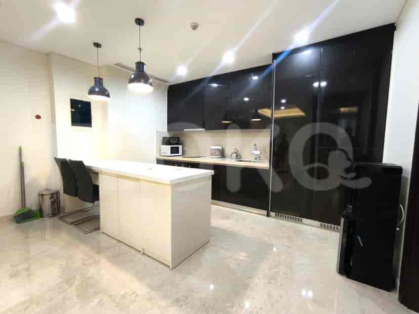 A modern kitchen with black cabinetry, a white countertop, and pendant lights.