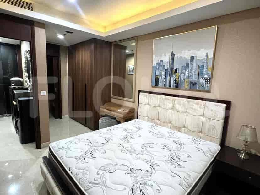 Bedroom with a large bed, artwork, and a dressing table.