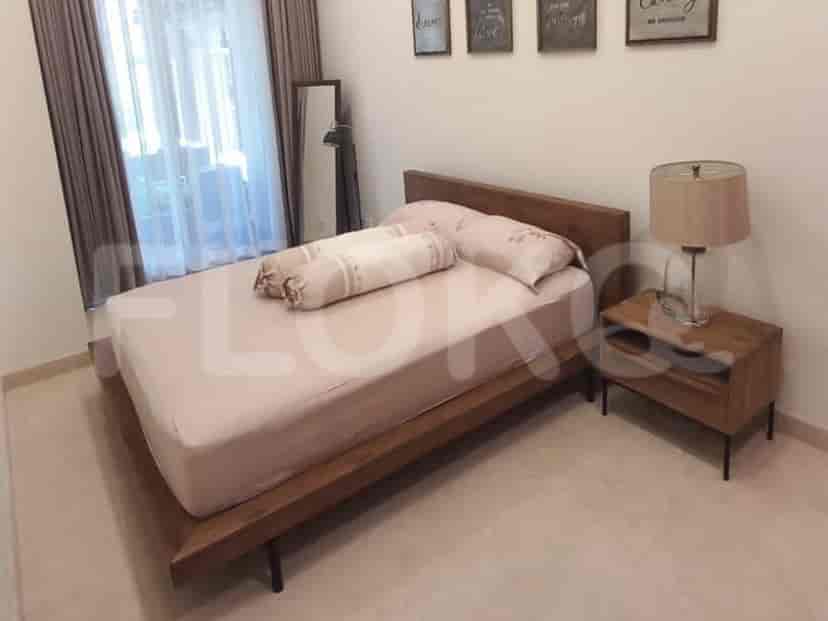 Modern bedroom featuring a wooden bed, lamp, and bedside table.
