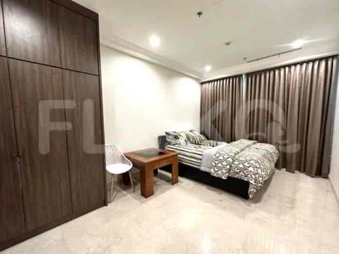 Bedroom with a bed, wardrobe, and a small table.