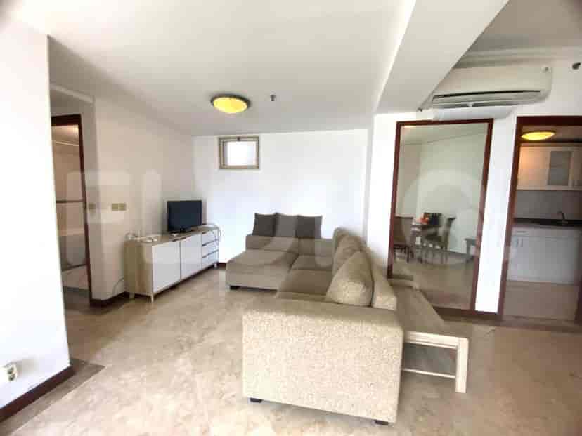 Living area with a sofa, a kitchenette, and a mirror, providing a sense of spaciousness.