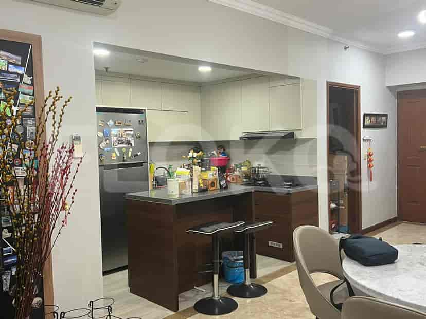 A compact kitchen with a breakfast bar, built-in cabinetry, and a stainless steel refrigerator.