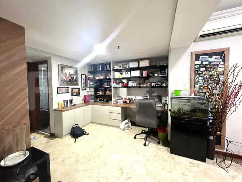 A home office with a built-in desk and shelving, featuring a fish tank and memorabilia.