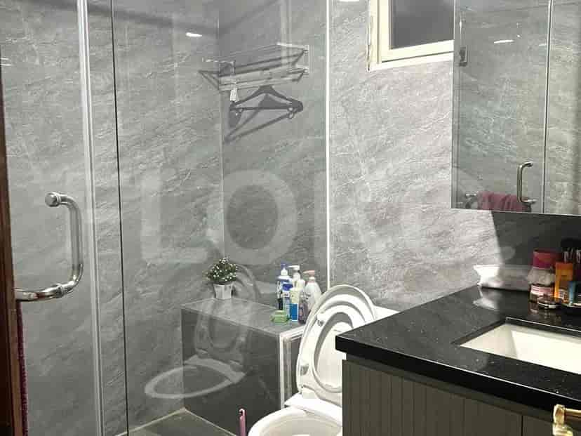 A modern bathroom with a glass-enclosed shower, toilet, and vanity.