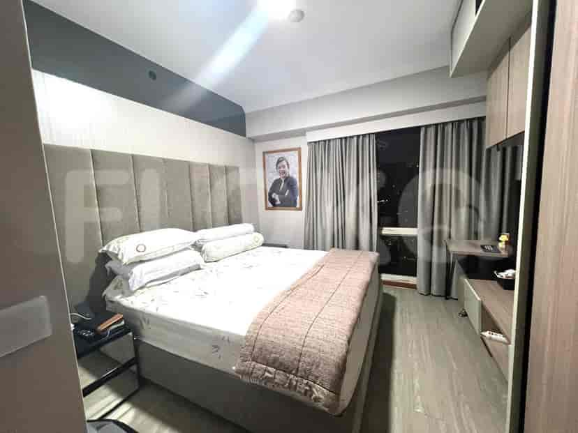 Cozy bedroom with a double bed, large window, and wooden cabinets.