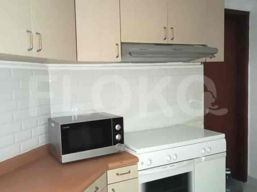 Small kitchen with basic appliances, including a microwave, oven, and overhead cabinets.