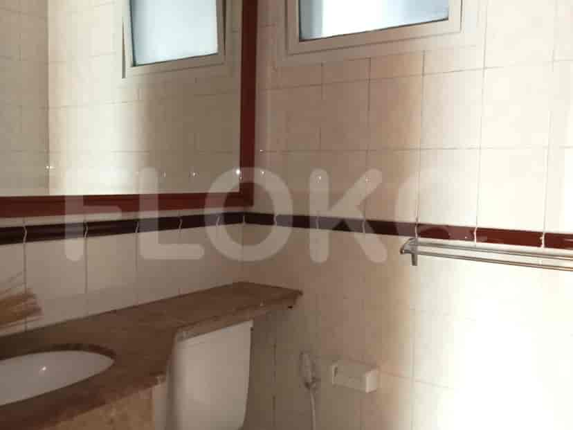 Bathroom with a toilet, a washbasin, and large mirror.