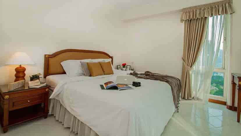 Kamar tidur dengan tempat tidur ganda, bahan bacaan, dan pemandangan.
