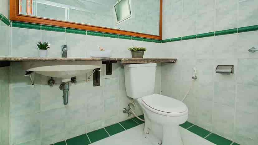 Kamar mandi dengan wastafel, toilet, dan cermin.