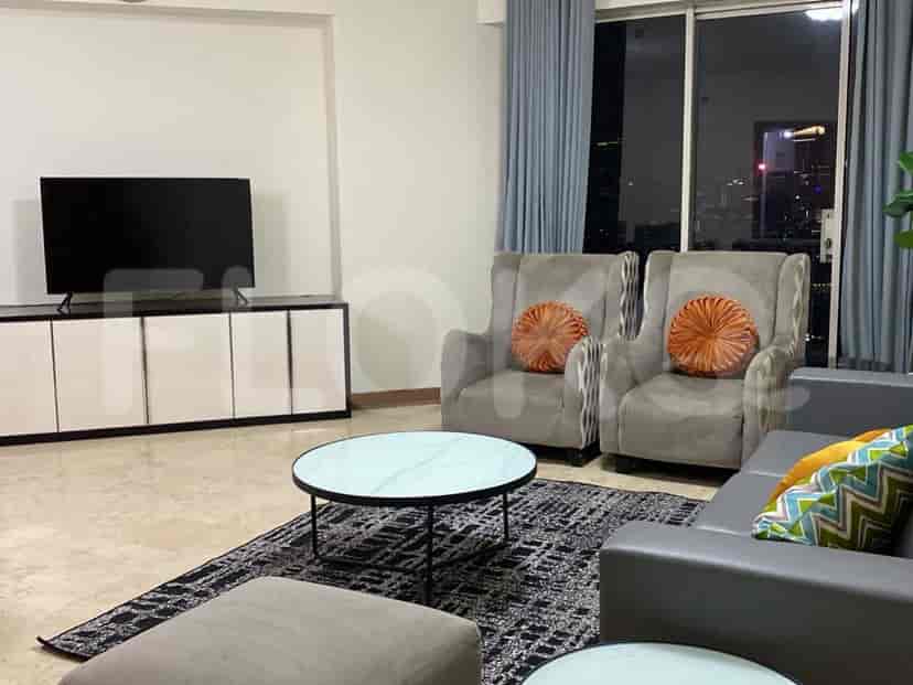 Living room with a sofa, armchairs, a TV and city view.