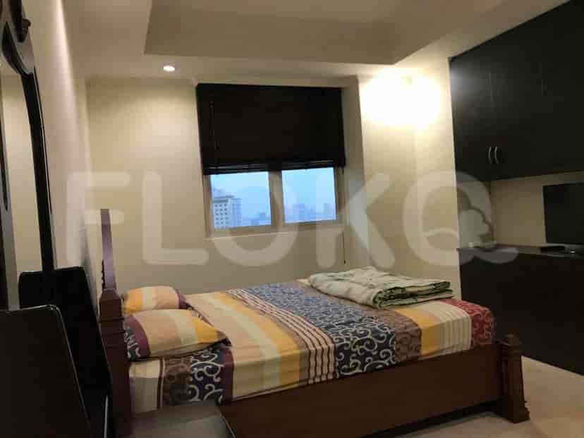 Kamar tidur dengan tempat tidur, jendela dengan tirai, dan penyimpanan built-in.