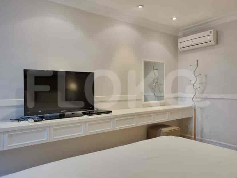 Bedroom with a mounted TV, vanity, and a coat rack.