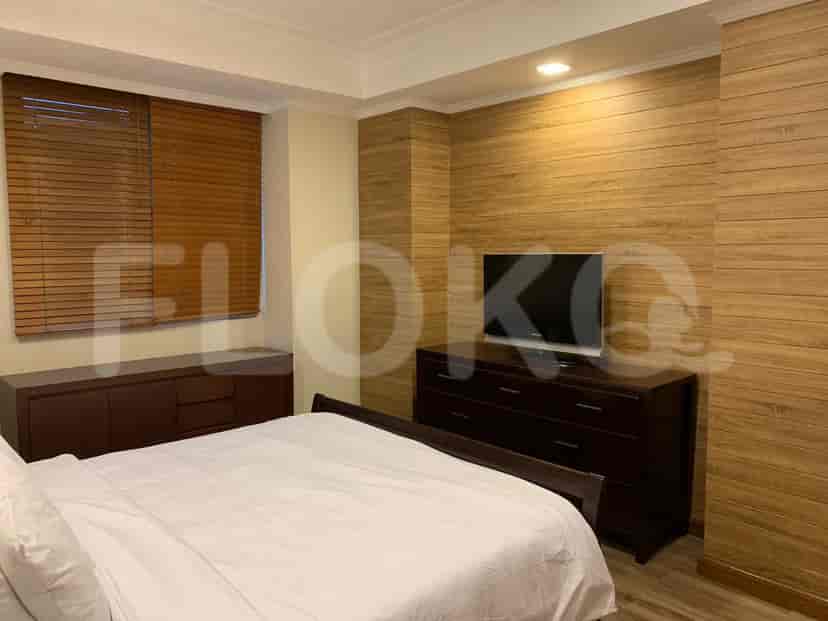 A bedroom featuring a bed, a dresser, and wooden blinds.