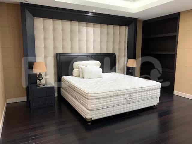 Kamar tidur mewah dengan tempat tidur besar, meja samping tempat tidur, dan sandaran kepala yang bergaya.