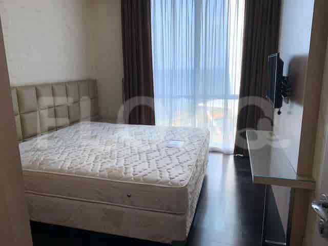 Kamar tidur modern dengan tempat tidur, gorden, dan TV yang dipasang di dinding.
