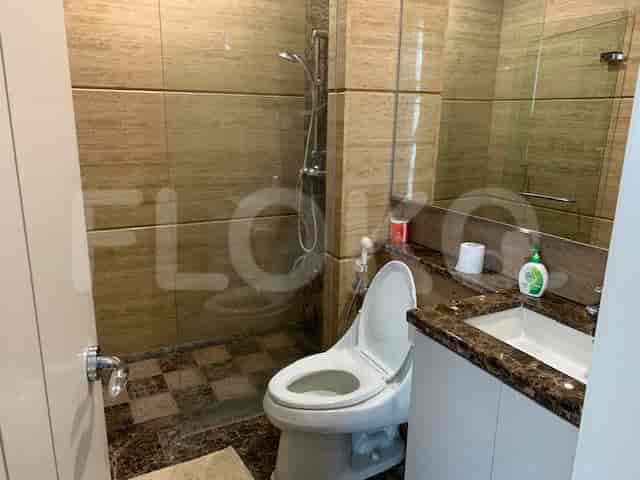 Kamar mandi modern dengan toilet, wastafel, dan pancuran walk-in.