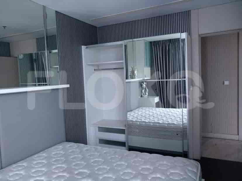 Kamar tidur yang menampilkan tempat tidur, lemari pakaian, dan aksen cermin.