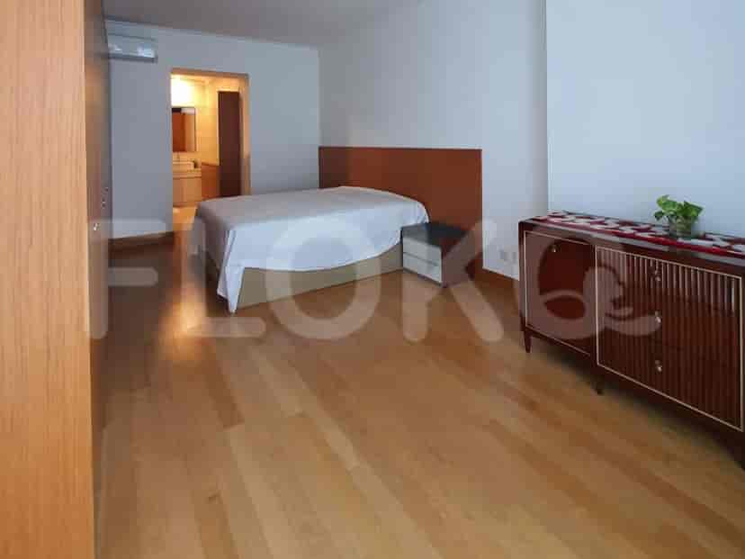 Kamar tidur dengan tempat tidur queen, headboard kayu, dan lantai kayu.