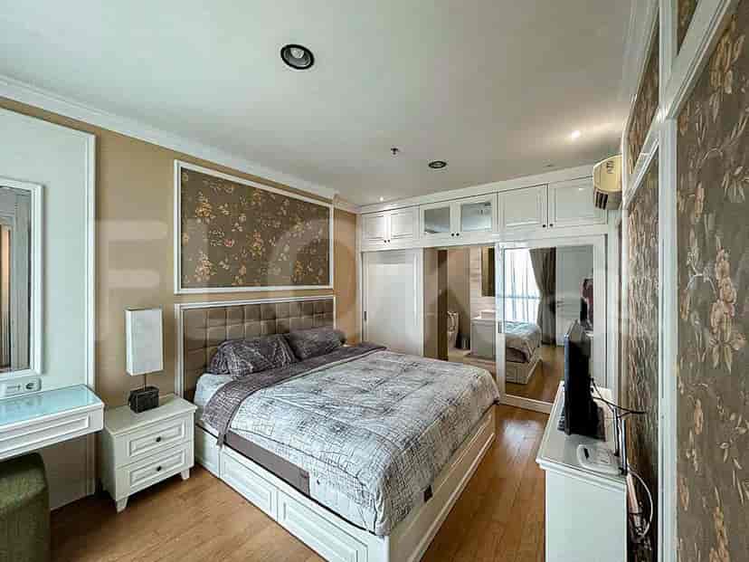 A well-appointed bedroom with a large bed, vanity, and built-in storage.