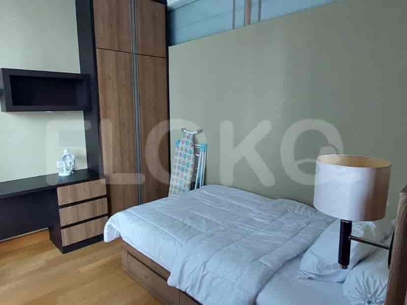 A bedroom with a bed, a desk, and a wardrobe.