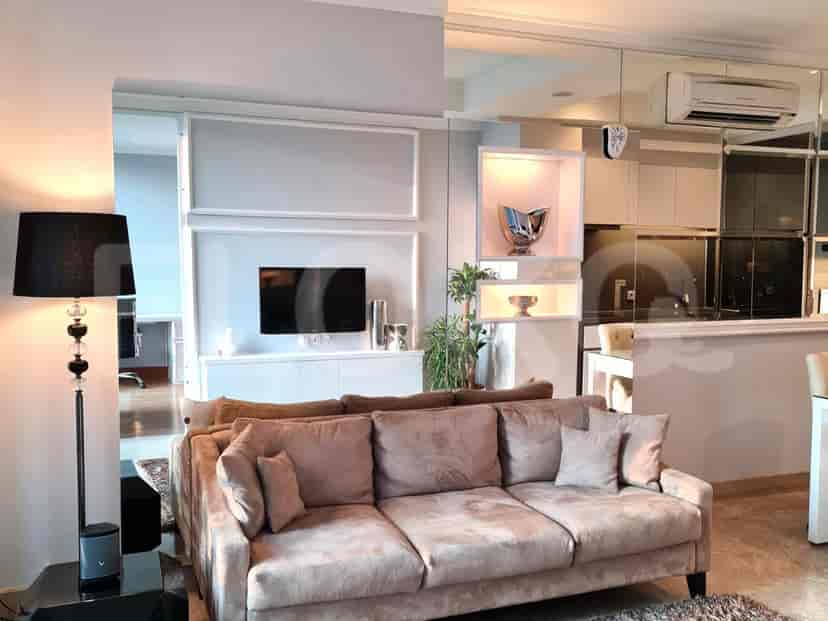 A luxurious living room with a velvet sofa, mirrored walls, and a view.