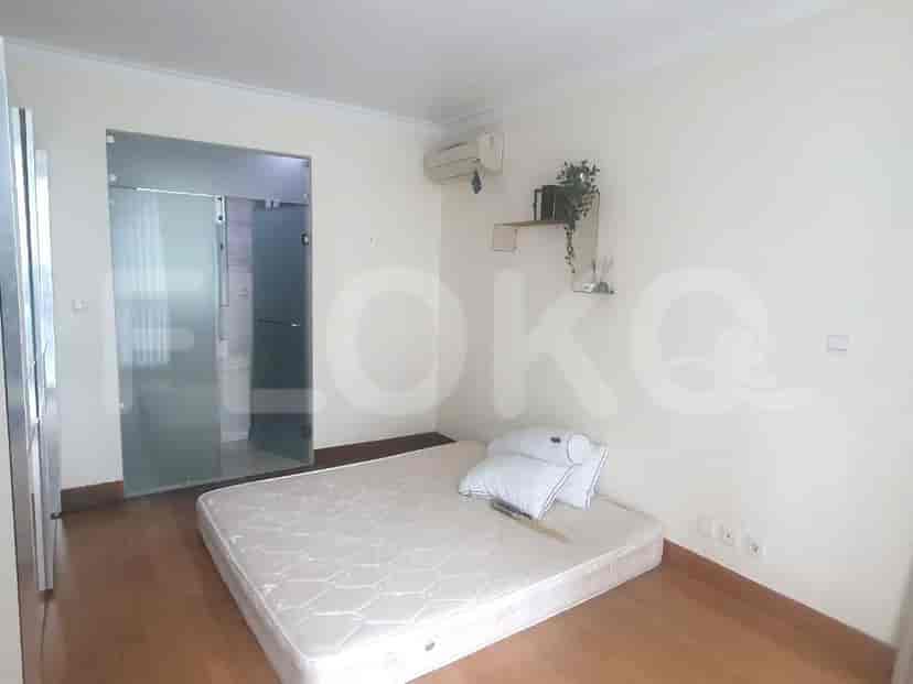 A bedroom with a bed, bathroom access, and a window with natural light.