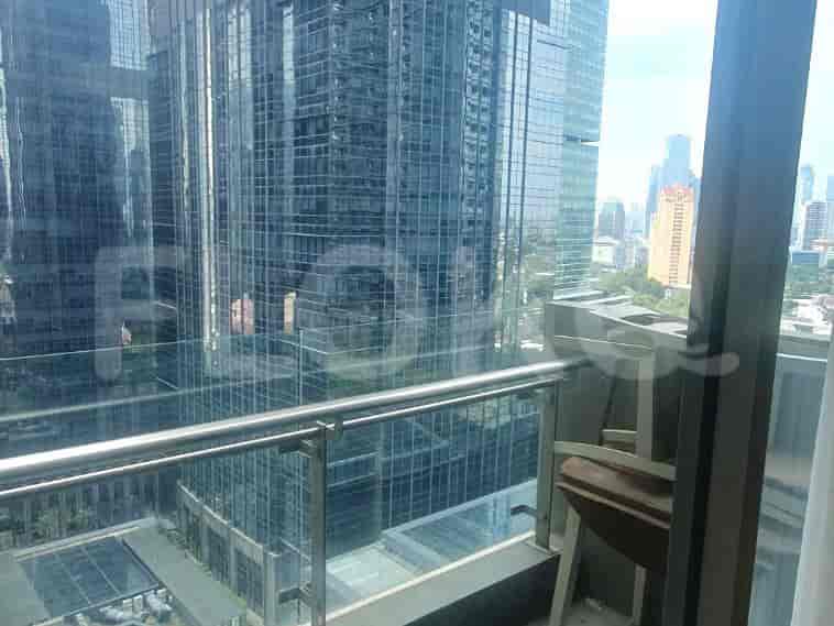 A balcony with a glass railing providing a great view of the surrounding buildings.