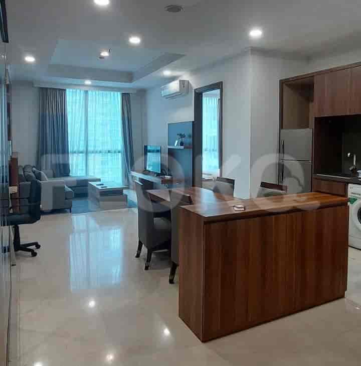 A modern living and dining space, with a sofa, dining table, and an open kitchen.