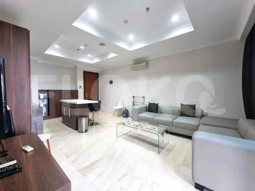 A modern living room and kitchen combo with a grey sofa, a kitchen island, and light flooring.