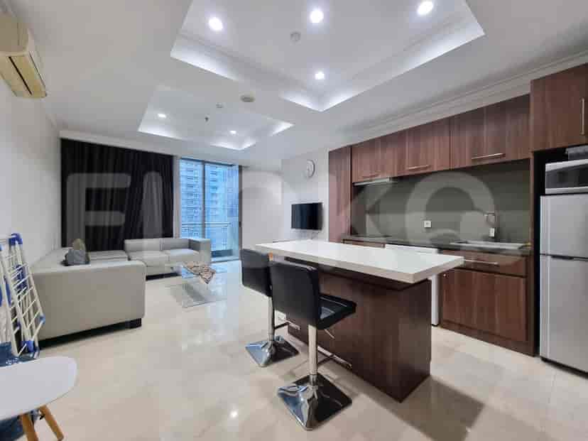 Living room and kitchen combo showing a sofa, kitchen island and city view.