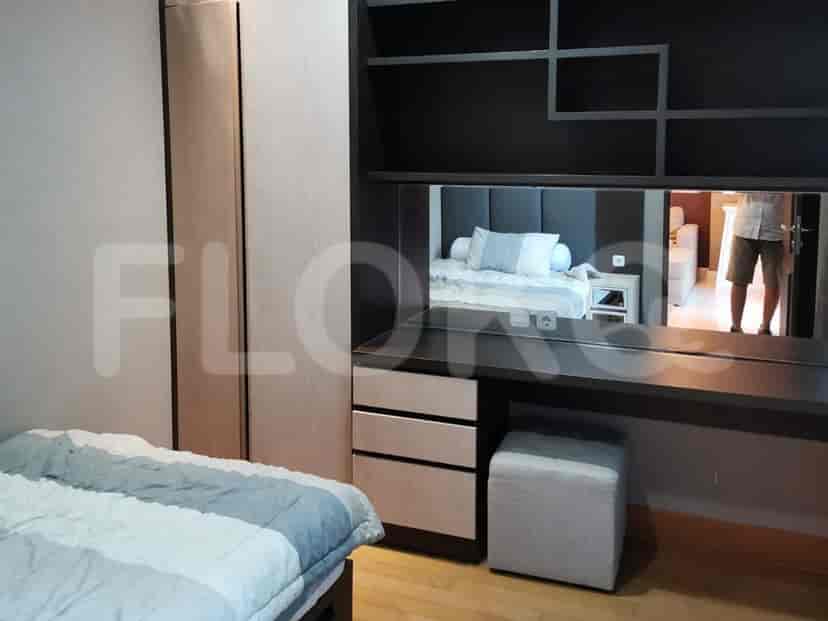 Modern bedroom with a dressing table, wardrobe, and large bed.