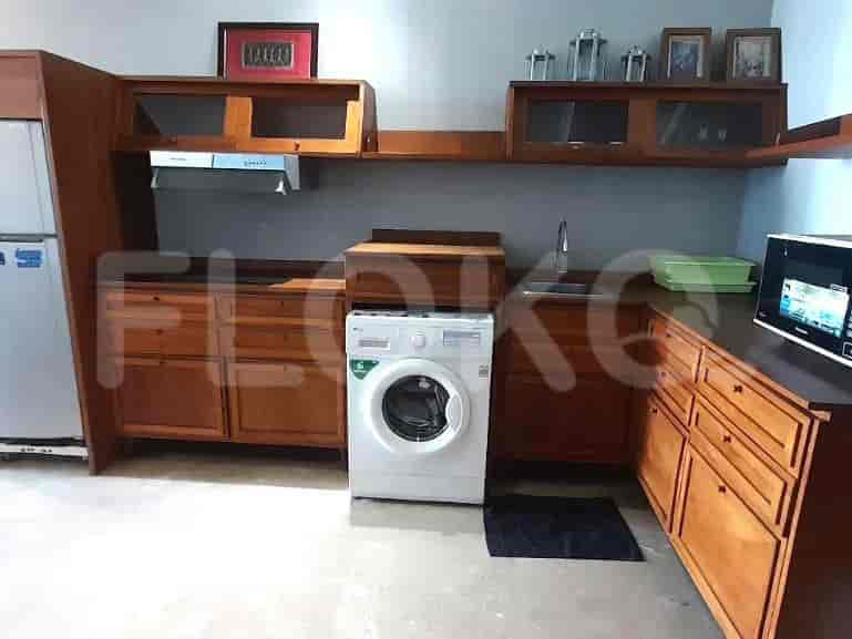 Kitchen with wooden cabinets and a washing machine.
