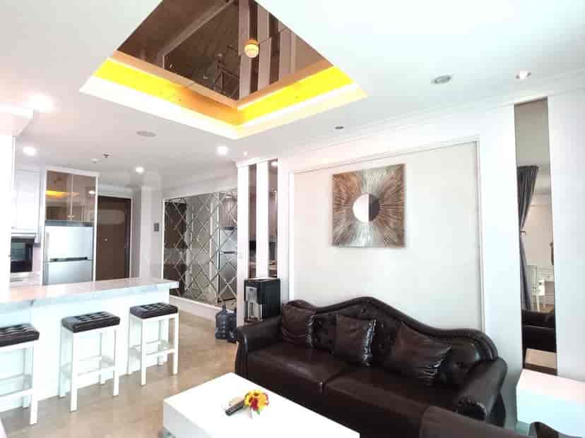 View of the living area with open kitchen, a modern design with mirrored ceiling.