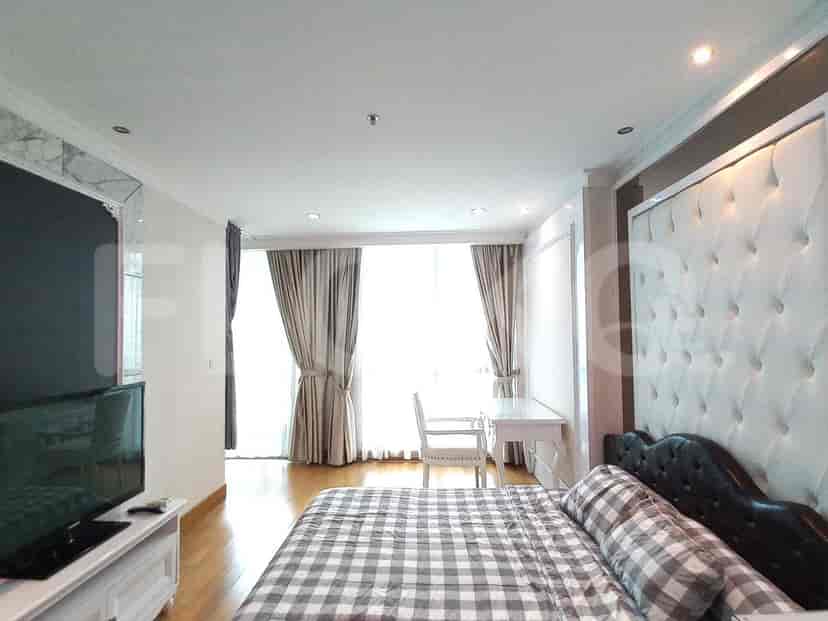 Spacious bedroom with a queen-sized bed, desk, and large window.