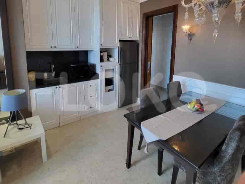A combined kitchen and dining area with white cabinets and a dark table.