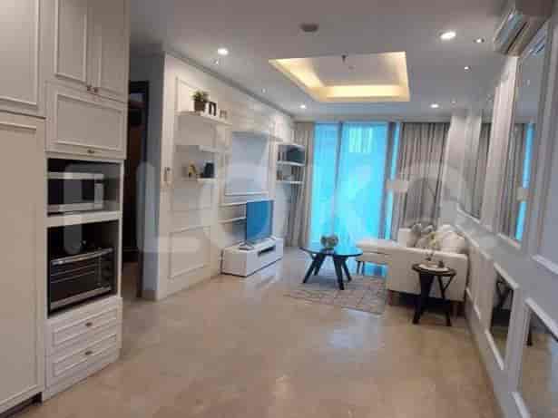 Another view of a modern living room with built-in cabinetry and a small kitchen.
