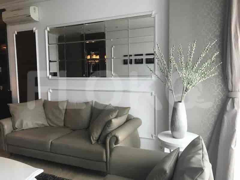 Living room with sofa, mirror, and decorative vase.